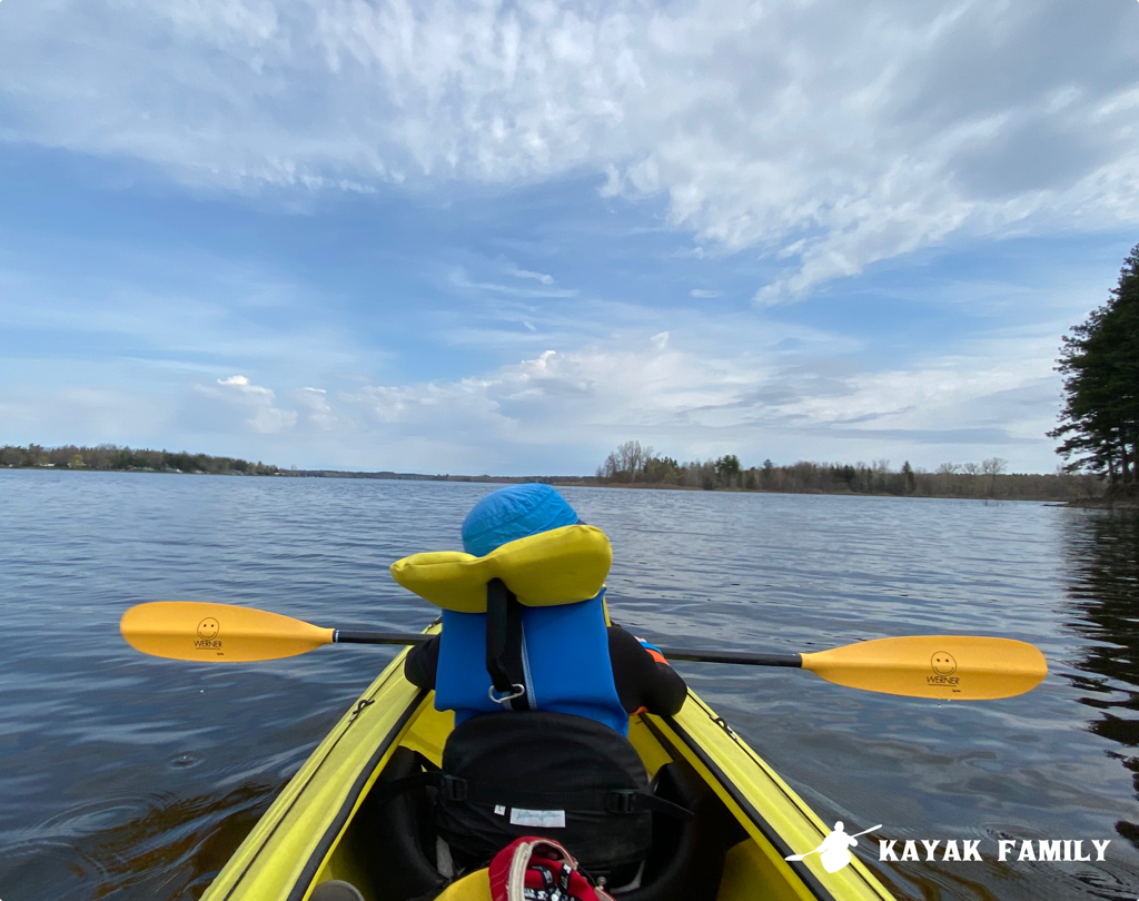 Child sits in the front of a tandem kayak at Belwood Lake in Ontario